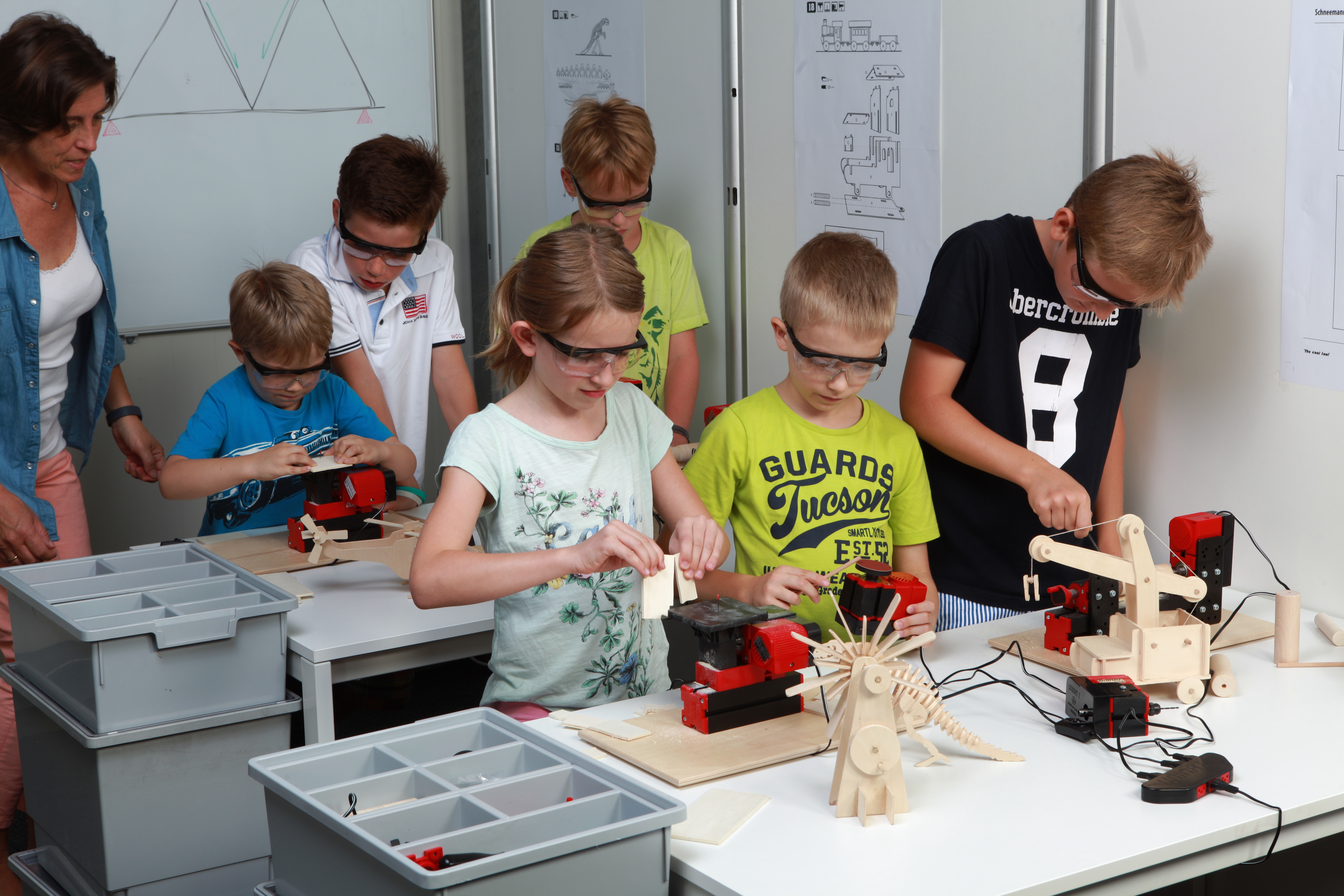 LP Werkunterricht Das Bild zeigt eine Klasse mit mehreren Kindern, die mit kindgerechten Werkzeugen arbeiten.