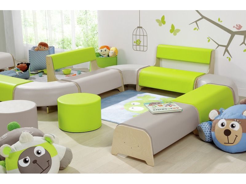 Man erkennt eine grüne Sitzbank in einem Spielzimmer