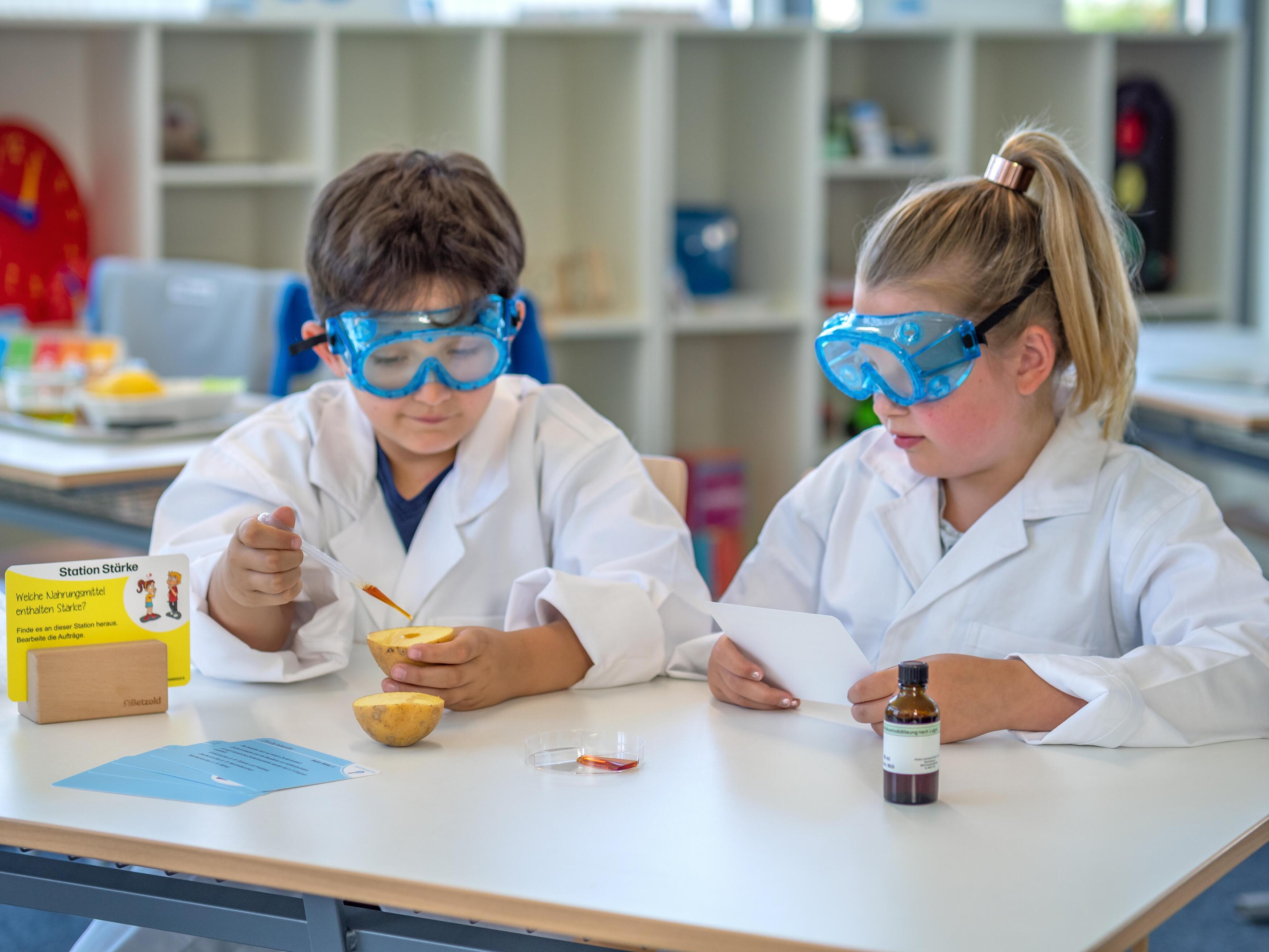 LP Experimente Das Bild zeigt zwei Kinder, die ein Experiment durchführen.