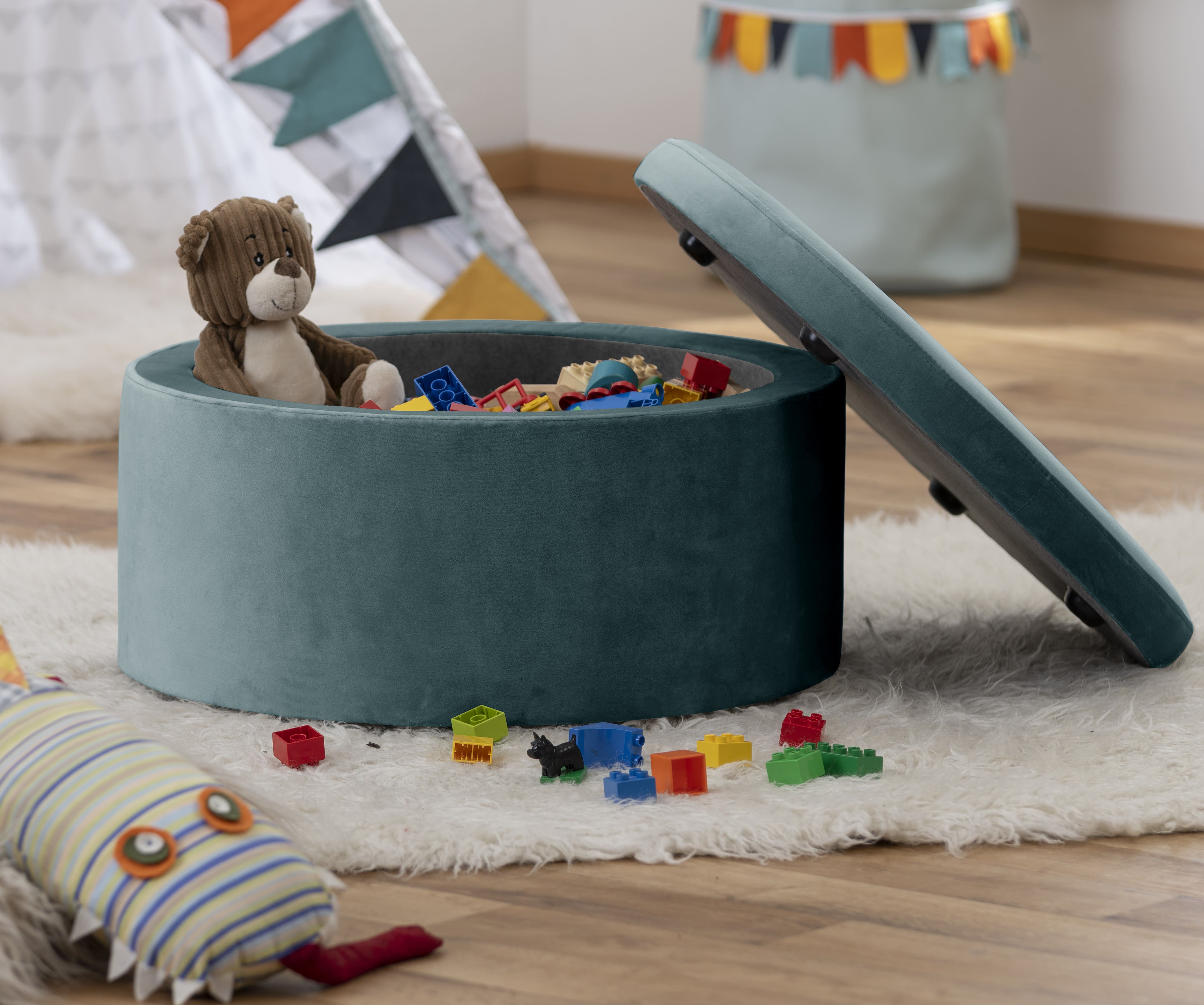 Man sieht einen Hocker, der mit Spielzeug gefüllt ist